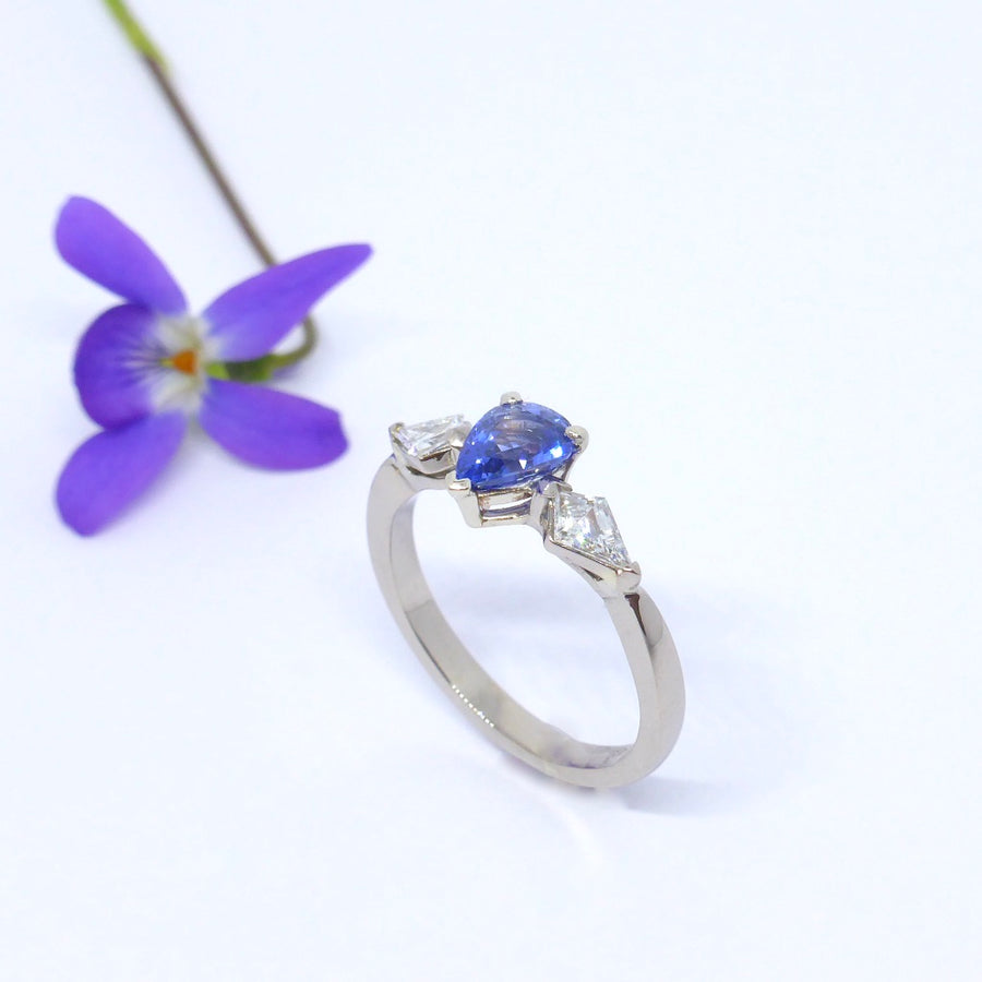 Kite diamonds sit next to a Stunning pear shaped Sapphire in this custom made Engagement ring by Louise Shaw Jewellery 