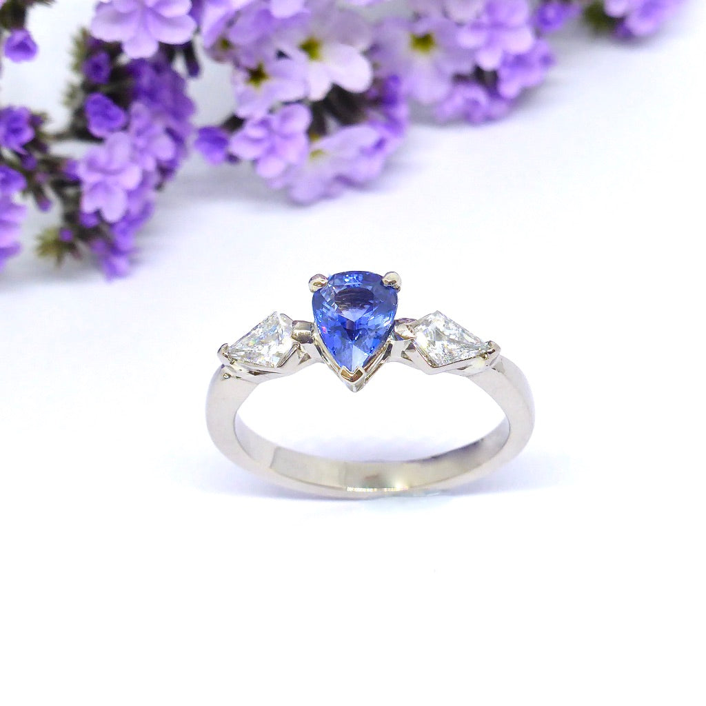 Kite diamonds sit next to a Stunning pear shaped Sapphire in this custom made Engagement ring by Louise Shaw Jewellery 